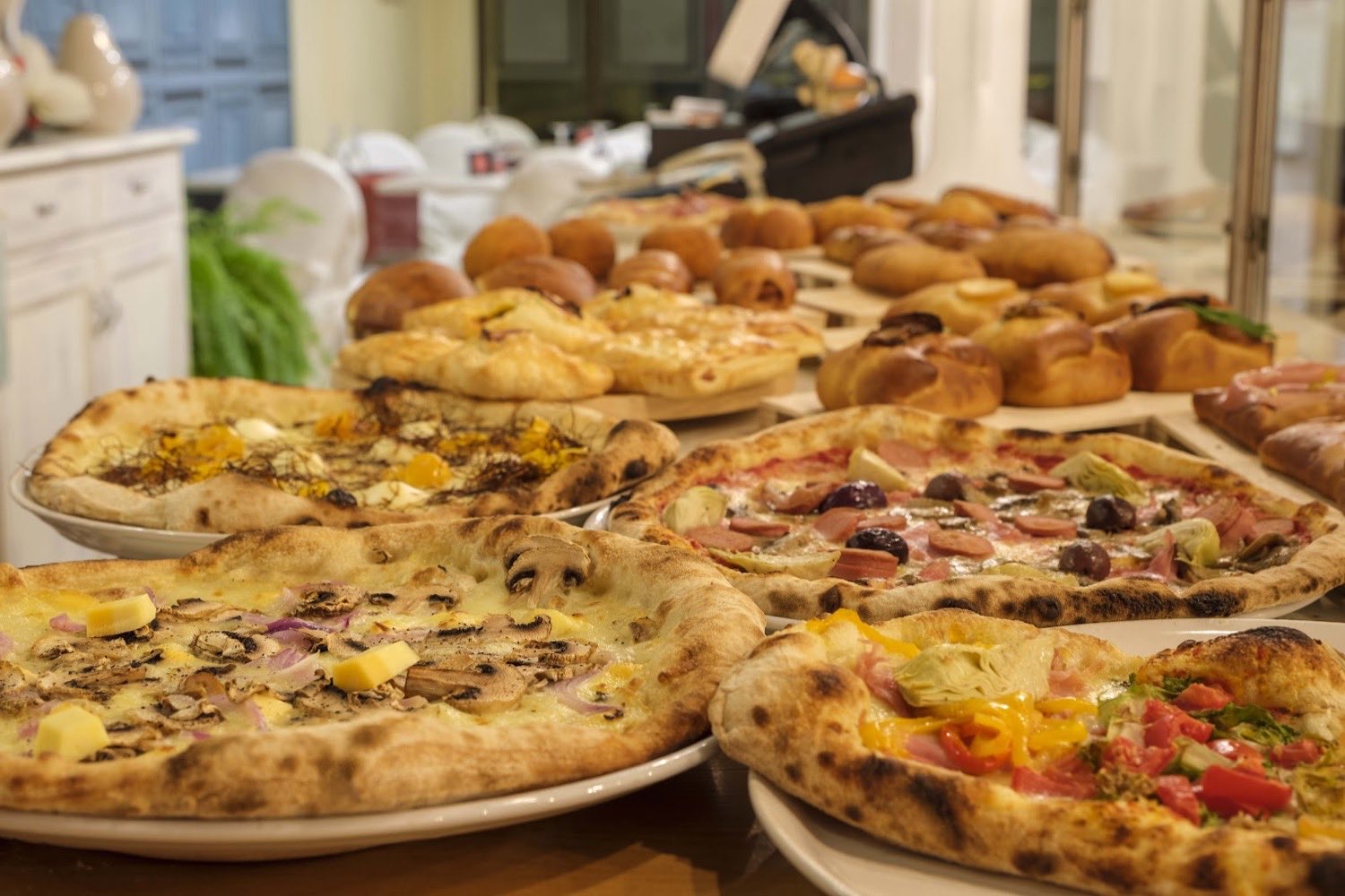 Tavolata di pizze, fritti e sfizi appena sfornati